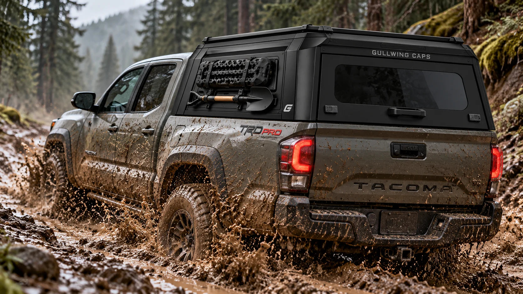 Toyota Tacoma with a GullWing MOLLE panel truck cap driving through mud on a forest trail